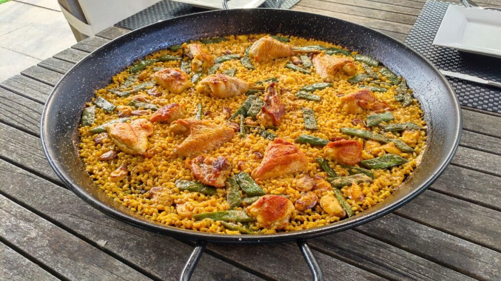 Paella au poulet – recette originale d’Espagne Paella espagnole au poulet, aux haricots verts et au safran dans une poêle à paella traditionnelle
